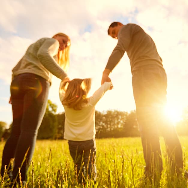 Happy family in golden field representing land ownership dreams